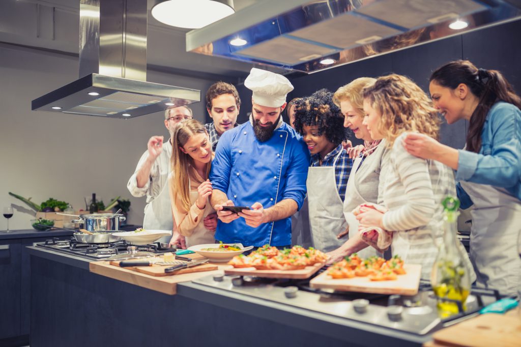 un chef et des apprenants à un cours de cuisine