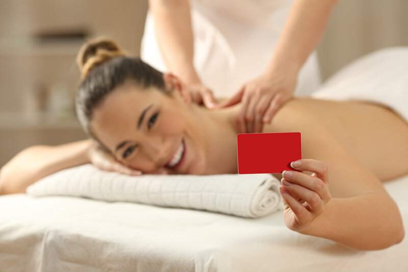 une femme souriante qui profite d'une carte cadeau massage offerte