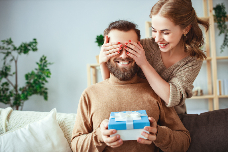 un couple marié et heureux offre une carte cadeau multi-enseignes à son époux