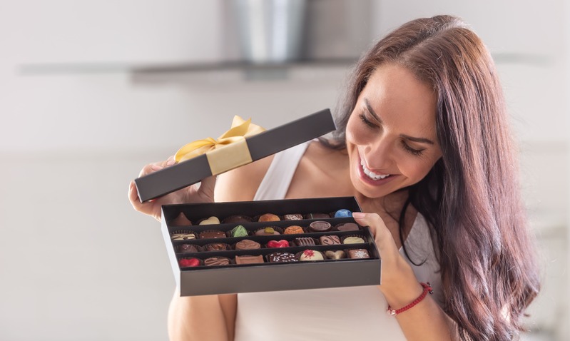 une maîtresse d'école ouvre une boite de chocolat reçue en remerciement de la part des parents