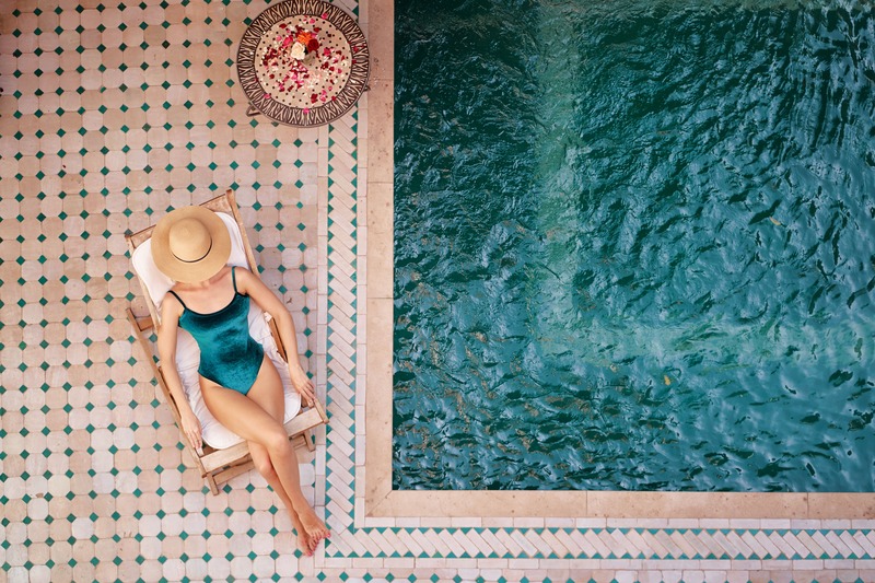 une femme se repose avec un chapeau autour de la piscine pendant ses vacances, une bonne idée de weekend entre filles farniente dans le sud
