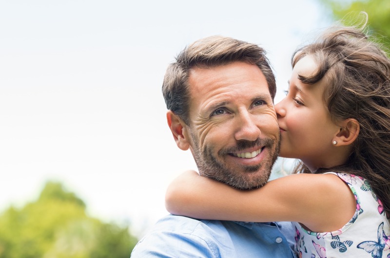 une fille embrasse son père suite à un cadeau père-fille