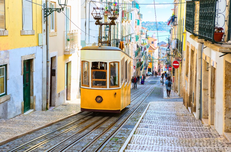 ville de Lisbonne au Portugal et le tramway urbain jaune avec la mer en arrière plan