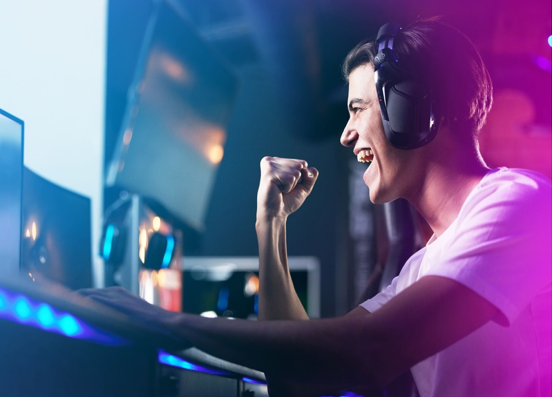 un joueur de jeux vidéo en ligne, un gamer fait le poing de la victoire, heureux de ses cadeaux jeux vidéo
