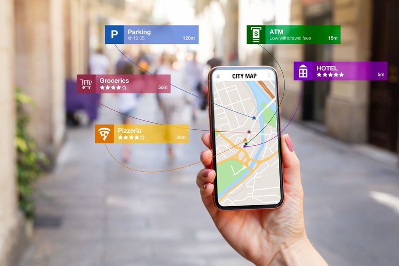 une personne tient en main un téléphone portable de façon utile en vacances et regarde une carte de la ville grâce à une application sur son téléphone mobile