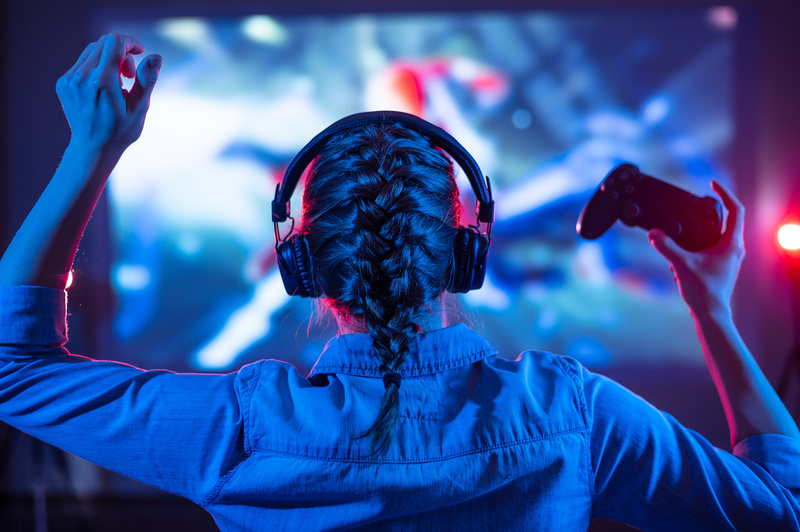 une jeune femme devant ses cadeaux jeux vidéo fait une partie de jeux