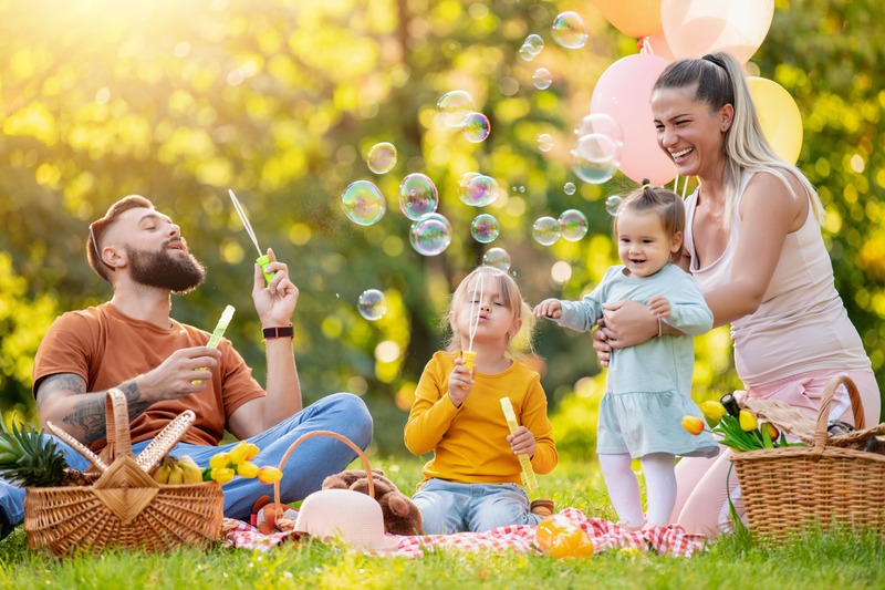 Une famille avec deux enfants à trouvé une activités à faire à paris, pique-niquer sur l'herbe et jouer dans un parc à paris pendant les vacances-scolaires
