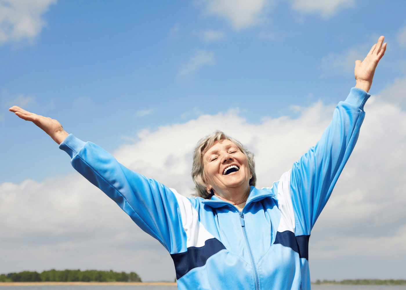 une femme âgée heureuse les bras en l'air