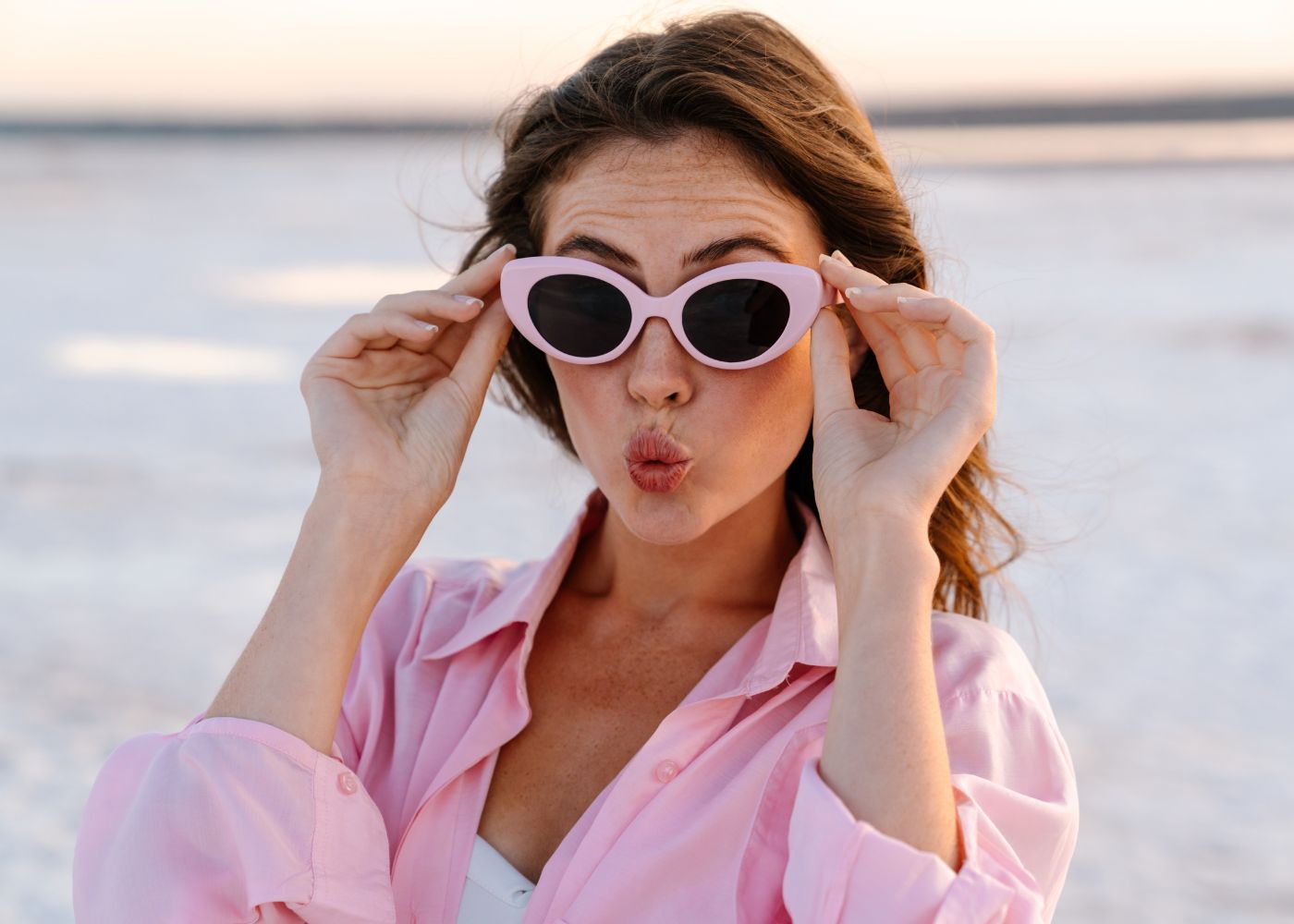 une femme surprise qui tient des lunettes de soleil