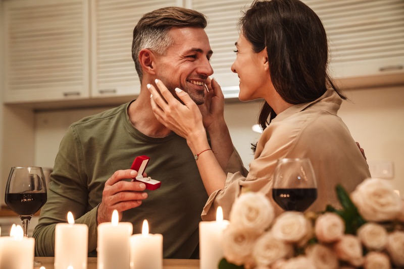une femme dit oui après une demande en mariage après lors d'un dîner aux chandelles à la maison