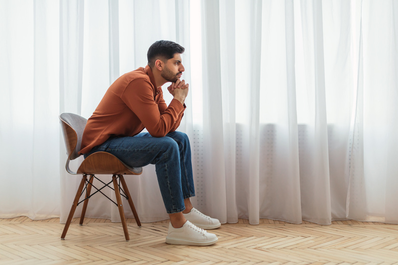 homme assis sur une chaise blanche et réfléchit à comment demander sa copine en mariage