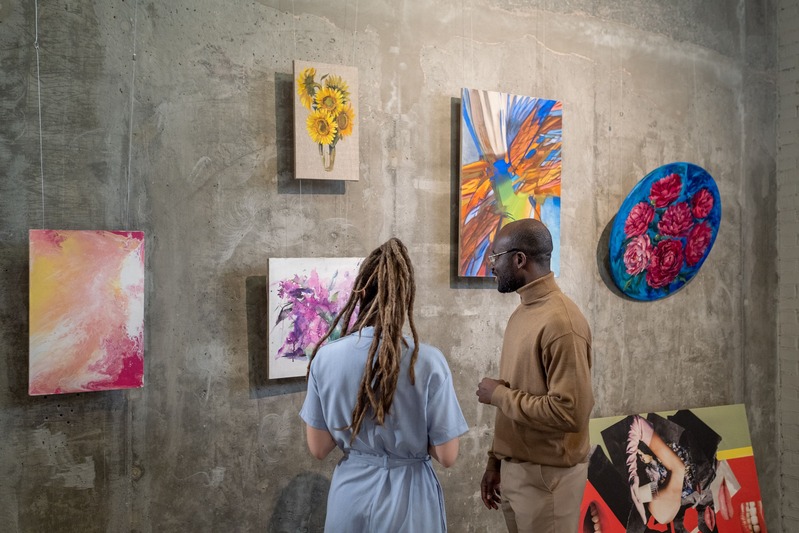 un jeune couple qui aime l'art, l'homme et la femme admirent des tableaux colorés