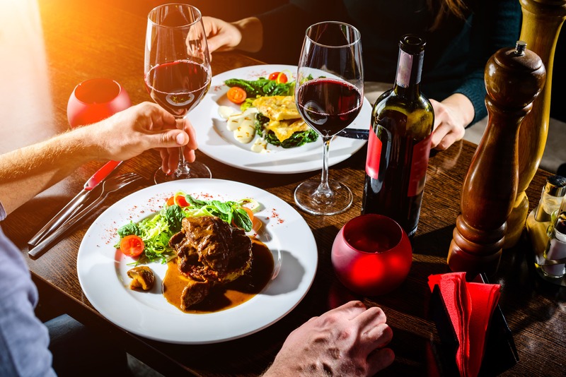 bonne idée de cadeau de mariage, un dîner gastronomique avec belles assiettes de chef et verres de vin rouge